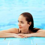 beautiful woman with perfect eyebrows and eyelashes relaxing in a swimming pool