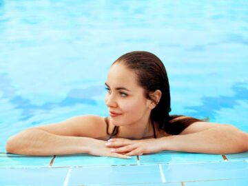 beautiful woman with perfect eyebrows and eyelashes relaxing in a swimming pool