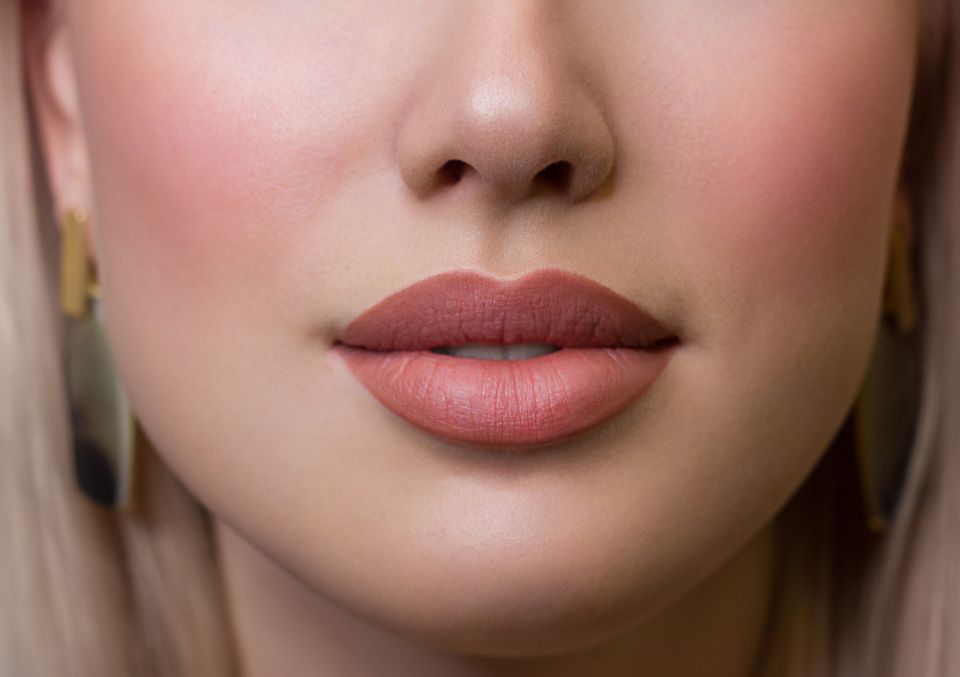 Beautiful full woman's lips after lip blushing cosmetic treatment