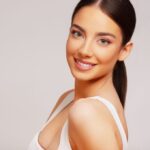 Face of a beautiful young woman with natural looking semi-permanent eyes make-up
