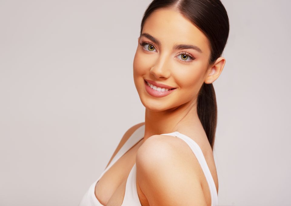 Face of a beautiful young woman with natural looking semi-permanent eyes make-up