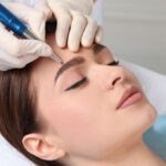Woman during cosmetic eyebrow tattooing